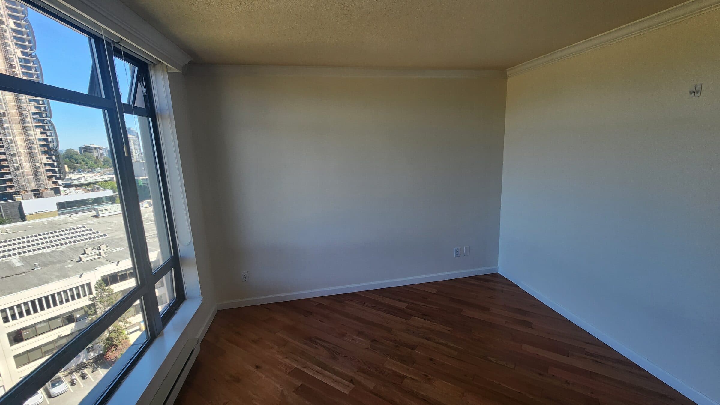 Daylight across the hardwood and fresh paintwork of a finished interior repaint